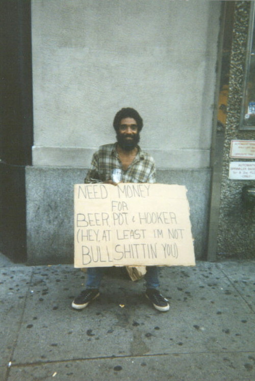 a Bum holding a funny sign.  At least he's telling the truth.  CLICK HERE